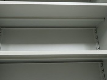 Adjustable steel shelf inside a steel office storage cabinet